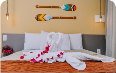 Suíte Tripla com cama preparada e decoração em tons claros