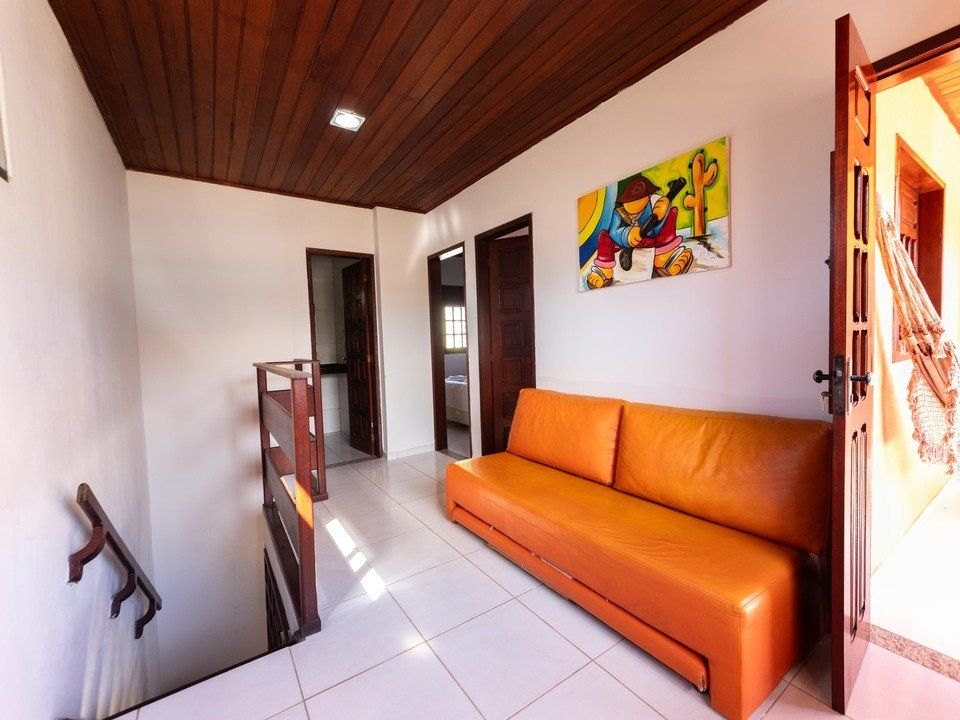 Sala de estar do chalé com sofá e acesso aos quartos