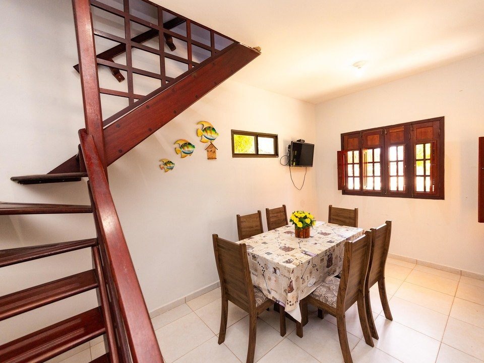 Sala de jantar com mesa para seis lugares e escada
