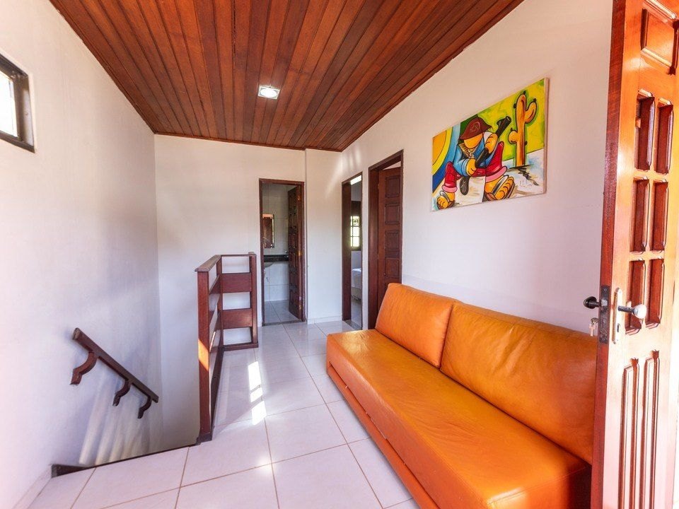 Sala com mesa de jantar, TV e janelas de madeira