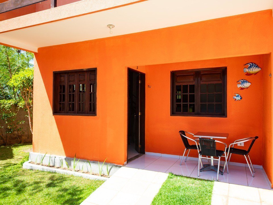 Varanda do chalé com mesa e cadeiras voltada para o jardim