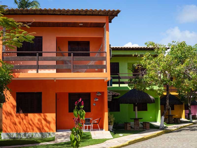 Bloco das suítes com varanda e jardim à frente