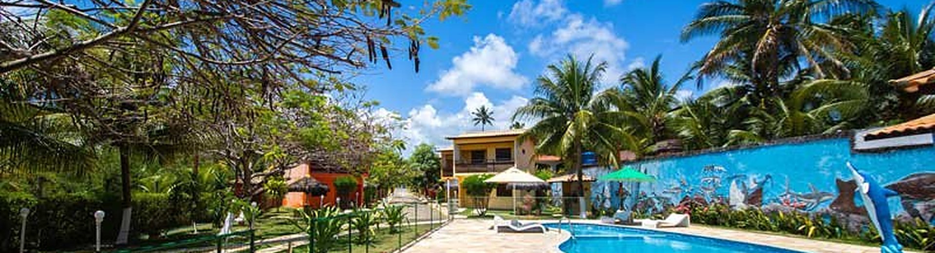 Piscina e chalés da Pousada Residencial Maragogi entre as árvores