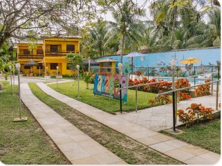Caminhos do jardim com rampa de acesso e a piscina ao fundo