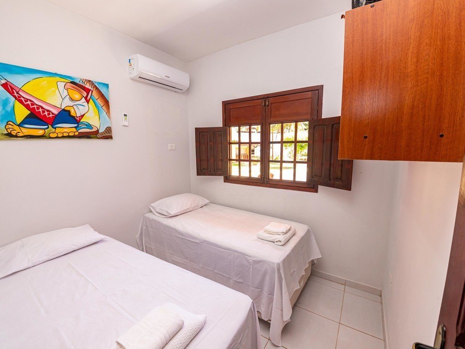 Suíte com cama de casal e janela voltada para o jardim